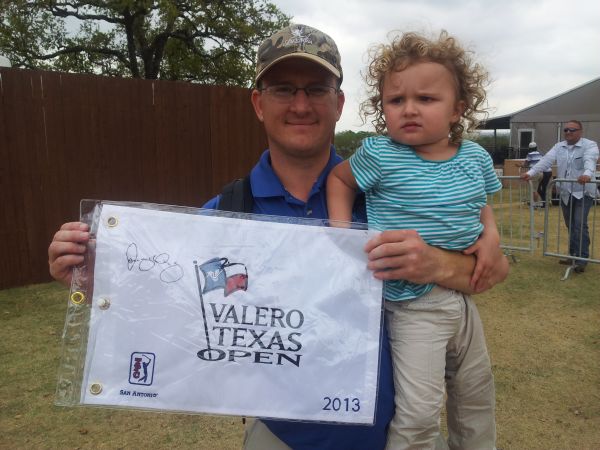 Lance Raska and his two-and-a-half year old daughter, Raegan with a signed Rory McIlroy Valero Texas Open commemorative flag. (Photo - www.golfbytourmiss.com)
