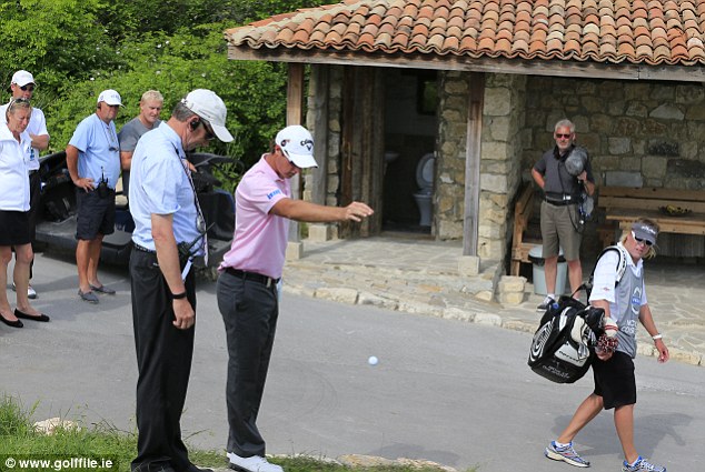 Nicolas Colsaerts, with his mother looking on (left of pic) taking a drop under Rule 24/2 at the 10th hole during his match with Graeme McDowell( Excusive Photo - Eoin Clarke/www.golffile.ie)