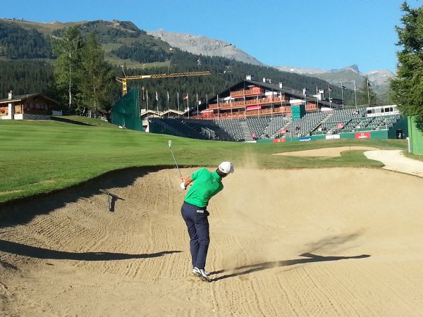 Matteo Manassero returns to golf after a three week break and seen here hitting out of a bunker in practice on the 18th hole at Crans-sur-Sierre.