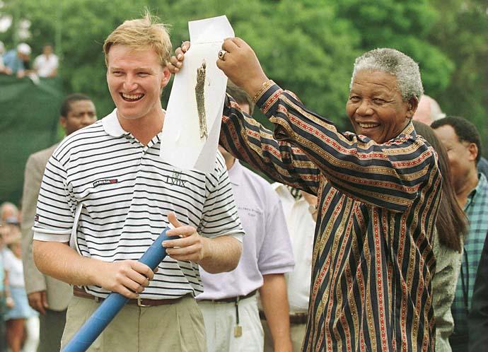 Ernie Els and President Nelson Mandela of South Africa share a laugh in February 1996 as Mandela shows a sketching of Els to the crowd before the final round of the Alfred Dunhill South African PGA Championship at Houghton Golf Club, Johannesburg, South Africa.