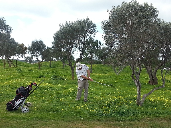 Captain John Howorth blasts his way out of the rough at the 3rd hole on the Oceanico Victoria course.