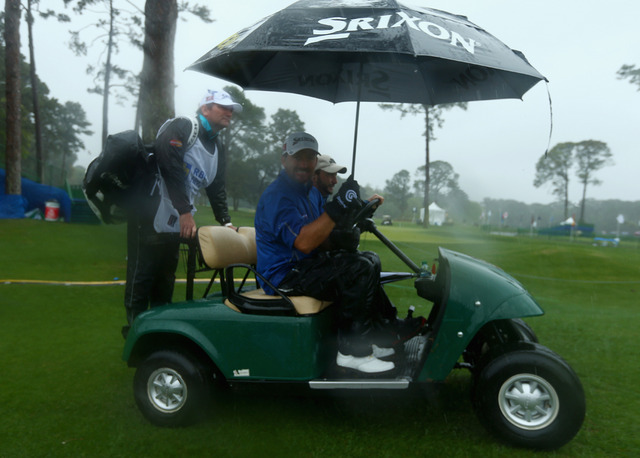 Graeme McDowell and his caddy being taken back to the clubhouse with rain halting play at Hilton Head.