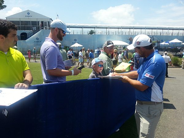 Padraig Harrington quizzes this young fellow 'Where's your teeth gone?' after his round of a two under par 70.  (Photo - www.golfbytourmiss.com)