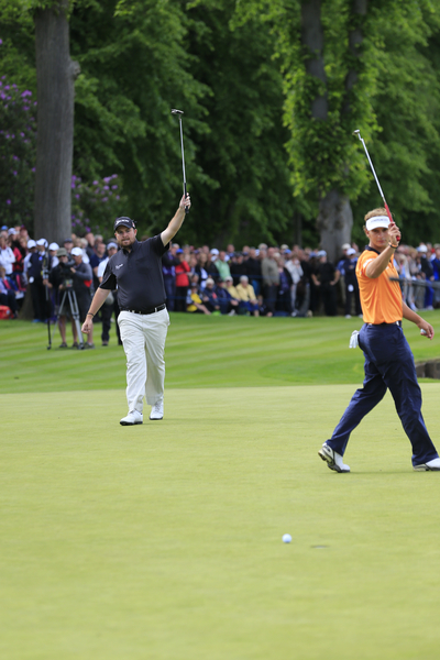 Shane Lowry holes a 30-footer for birdie at the last to secure second place as Joost Luiten shows his support for his Irish colleague. (Photo - Fran Caffrey/www.golffile.ie)
