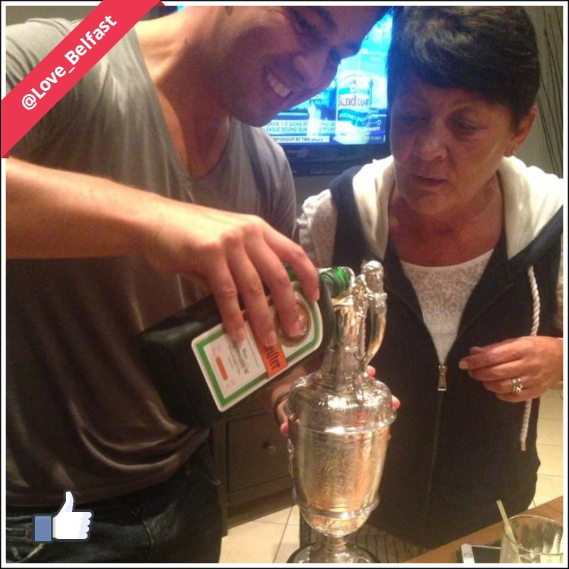 Harry Diamond, and one of Rory McIroy's closest friends, pours Jagermeister into the Claret Jug as Rory's mum, Rosie looks on.