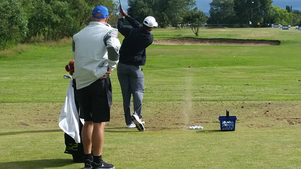 Woods brings up the dust in hitting a practice range shot. (Photo - www.golfbytourmiss.com)