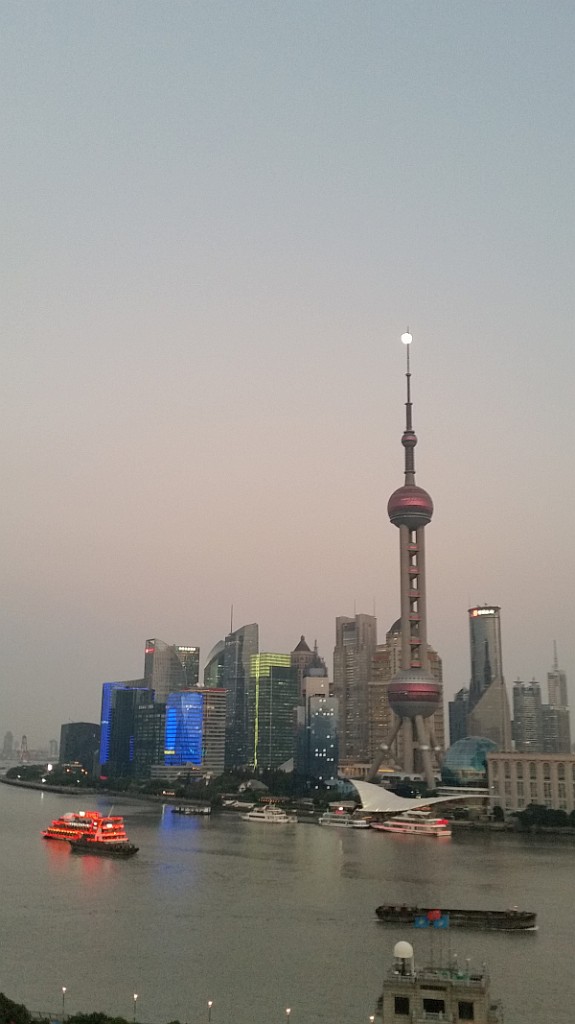 Darkness is about to set in as the full moon finds its way to the top of the Oriental Pearl Tower.