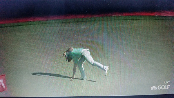 McIlroy picks the ball out of the cup on the 18th after a round of 76.