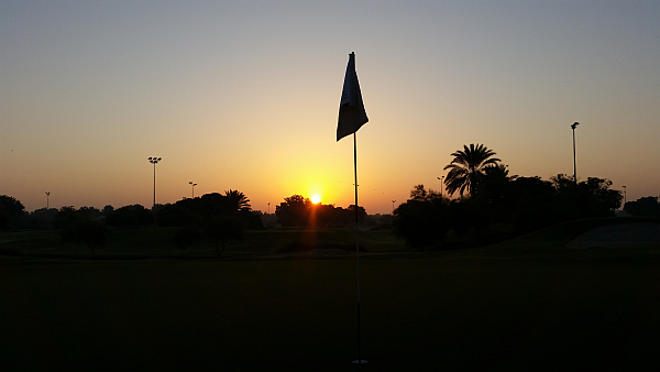 The sun begins to rise over the Emirates Golf Club, Dubai.