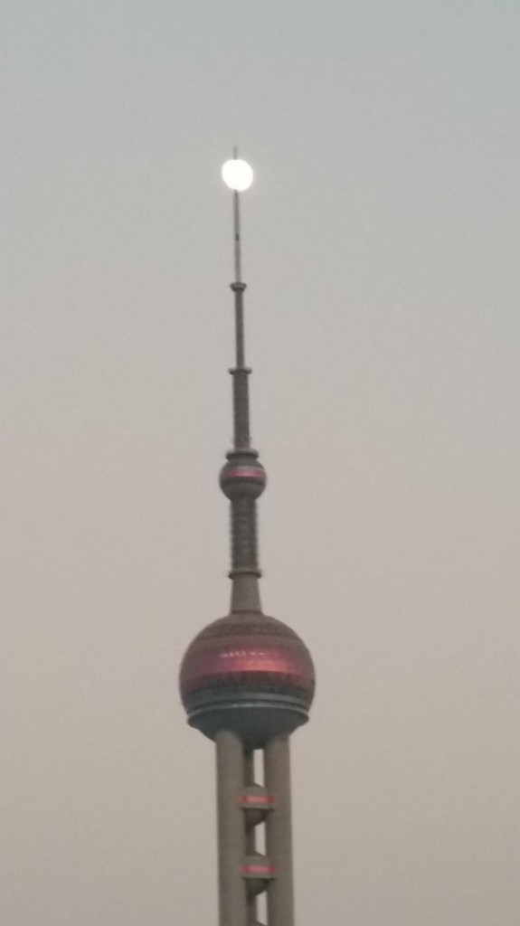 The full moon 'sits' atop of the Oriental Pearl Tower in Shanghai.