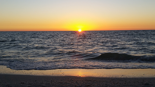 The sun slowly dipping into the Gulf of Mexico.