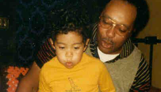 A two-year old Tiger Woods blows out the candles on his birthday cake as a proud father looks on. (Photo - Tiger Woods Foundation).