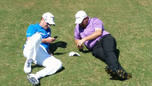 Marc Warren and Ireland's Shane Lowry checking text messages while waiting to tee up during a Tuesday practice round in the 2015 Valero Texas Open. (Photo - www.golfbytourmiss.com)