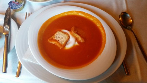 Rich tomato soup with a poached egg .