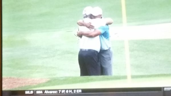 Tiger Woods and Mark O'Meara embrace after nine holes of practice.