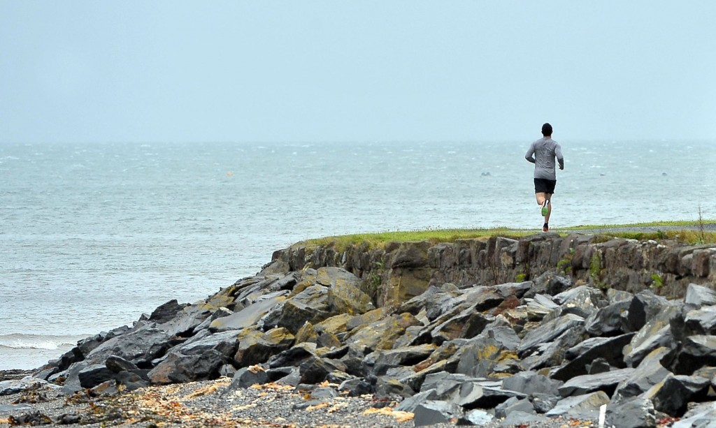 Rory McIlroy cuts a lone figure training along the Irish Sea shoreline.