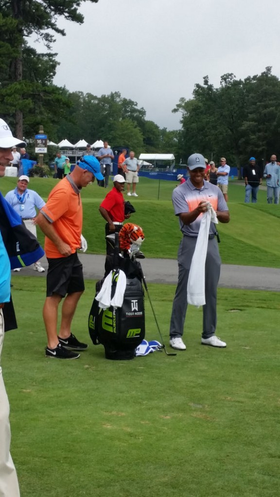 Tiger cleans Joe's 8-iron after Joe played his shot off the 16th tee.