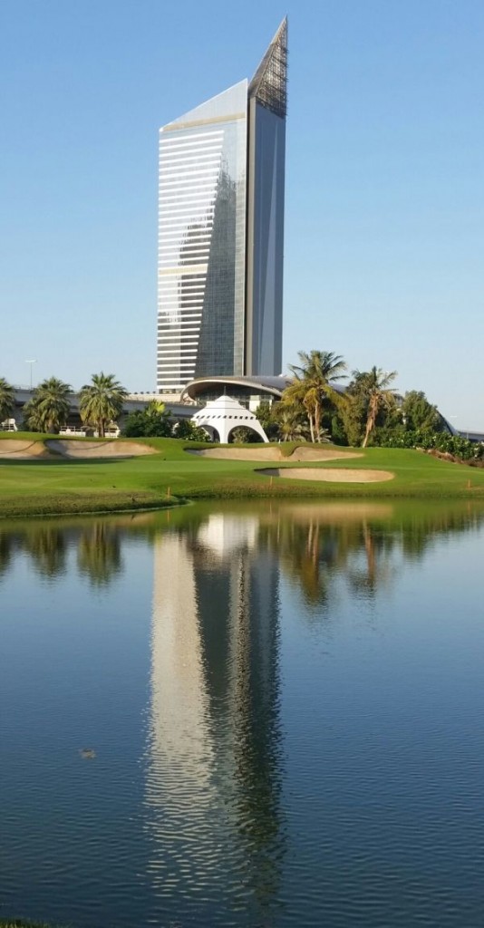 A new tower building dwarfs the ninth green.