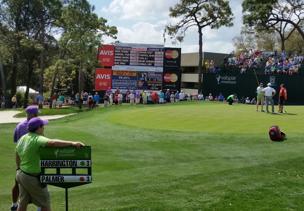 Padraig Harrington (green shirt on green) lining up the last putt of his round.