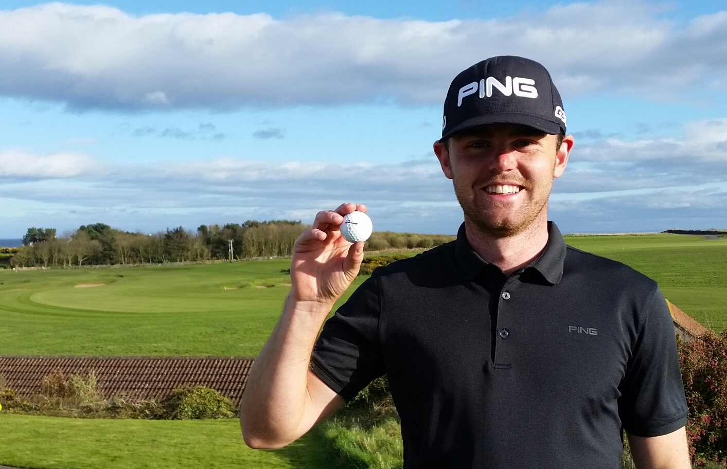 Liam Johnston delighted to have aced the par four 10th hole (behind him in the photo). (Photo - www.golfbytourmiss.com)
