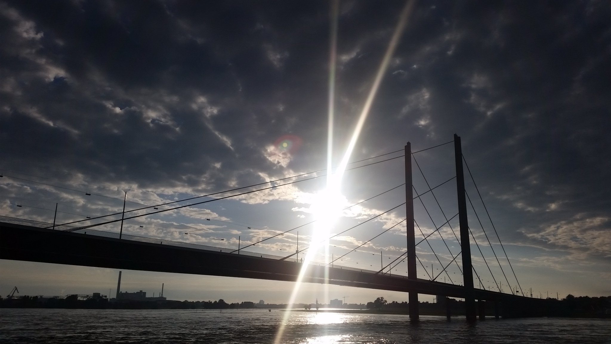 The sun setting over the Oberkassel Bridge at Dusseldorf