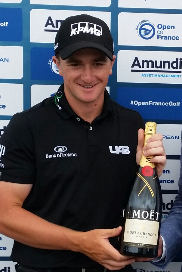 Paul Dunne proudly holds aloft a magnum of Moet and Chandon for the second ace of his pro career. (Photo - www.europeantour.com)