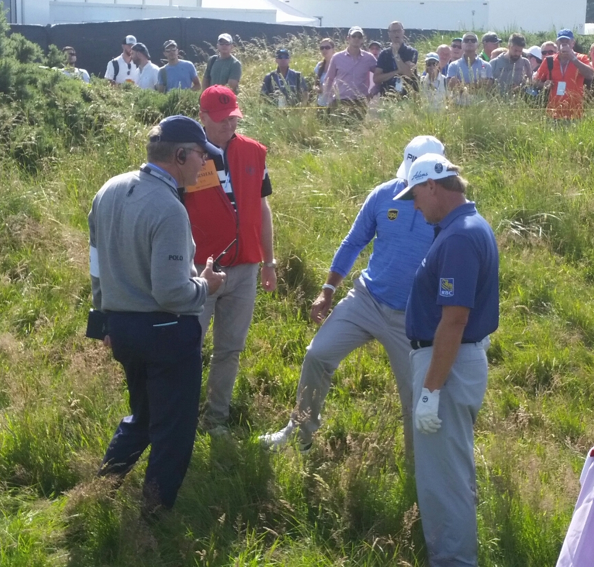 England's Lee Westwood has Ernie Els ball under his foot after standing on it during a search at the 12th hole on day one of the 2016 Open. (Photo - www.golfbytourmiss.com)