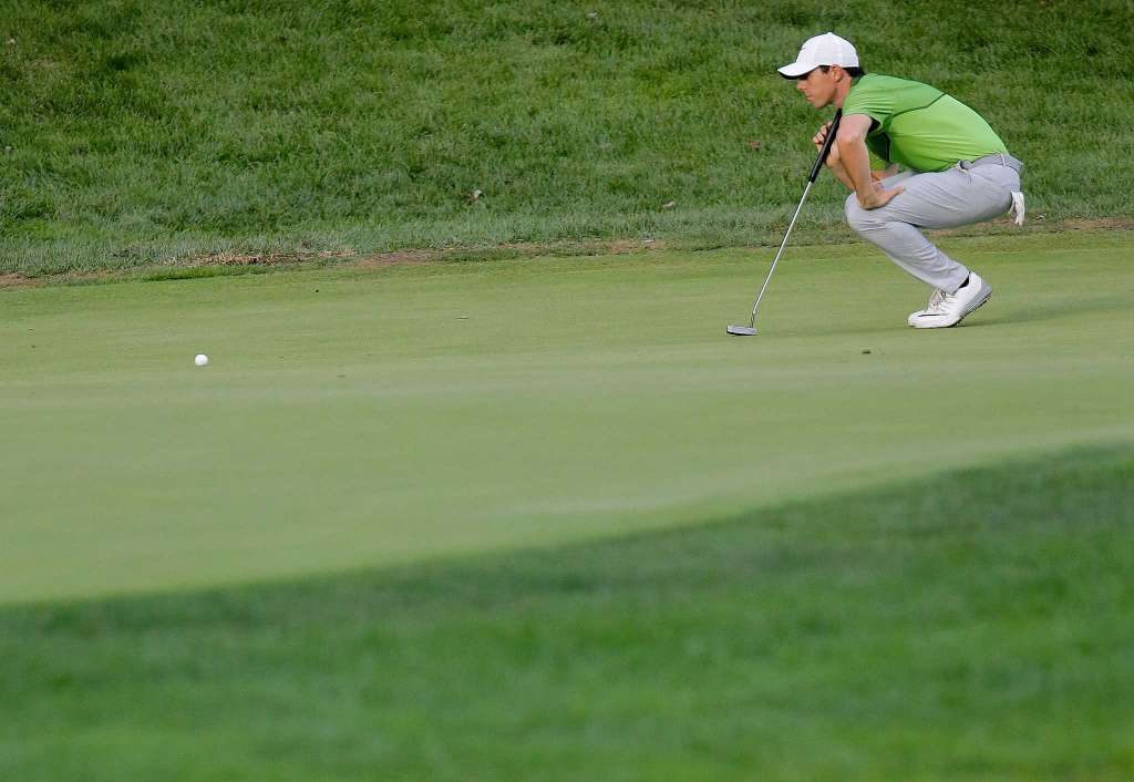 Rory McIlroy carefully studying a putt during his opening round.