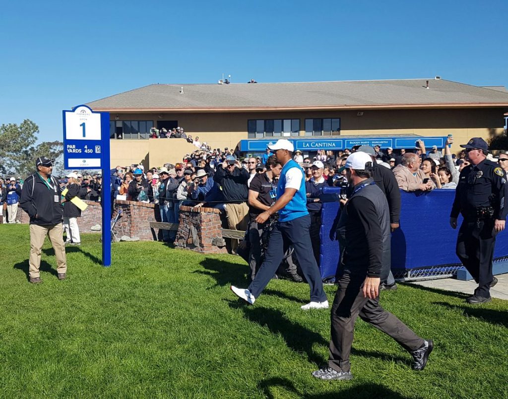Tiger Woods makes his way to the first tee and in an event he's won seven times.