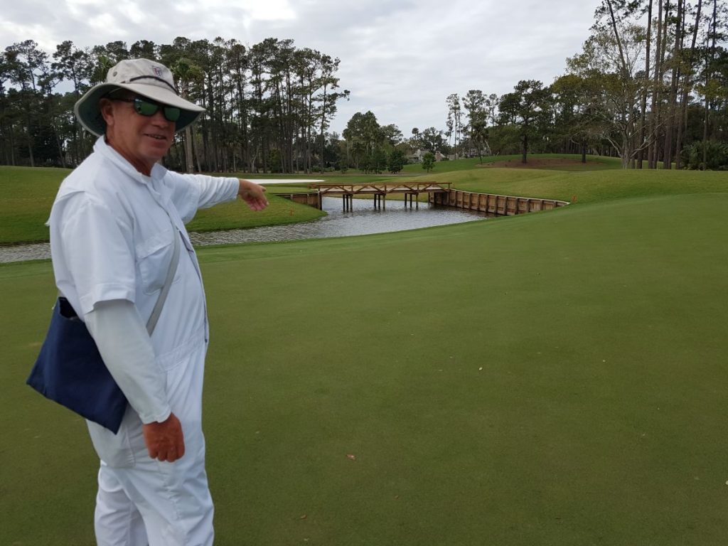 TPC Sawgrass caddy Donald points to the new water hazard and bridge to the left of the green at the par four 12th hole